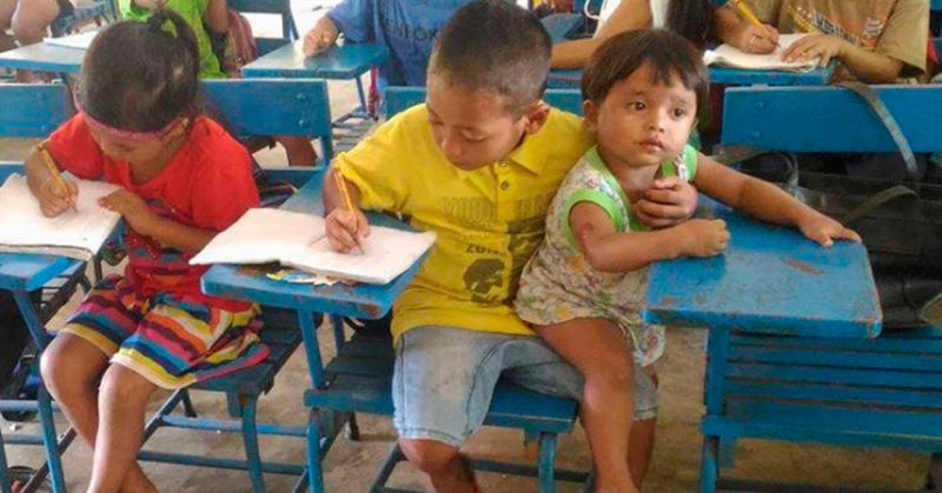 Niño de 7 años cuida a su hermano mientras estudia en la escuela