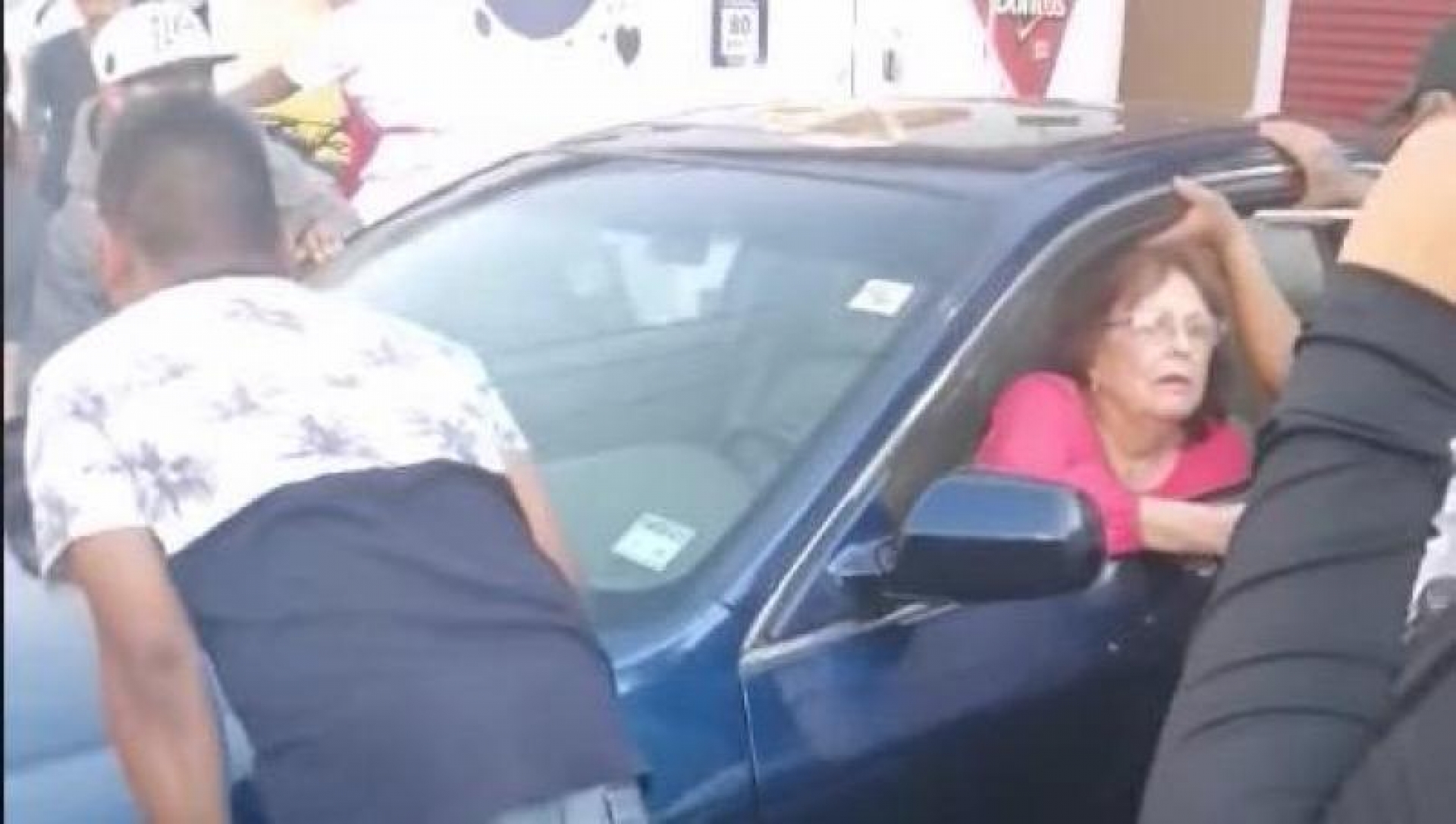 VIDEO: Unen fuerzas para mover a señora que se estacionó a la mitad de la calle