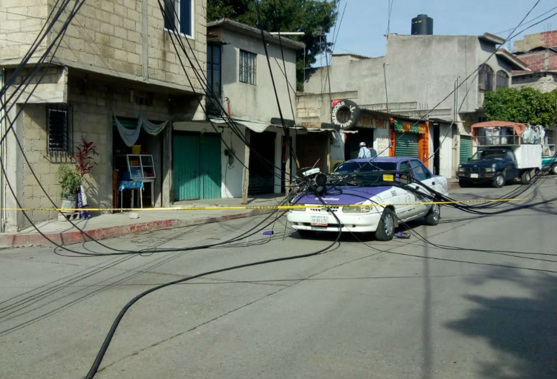 Cae poste de teléfono sobre taxi, en Emiliano Zapata